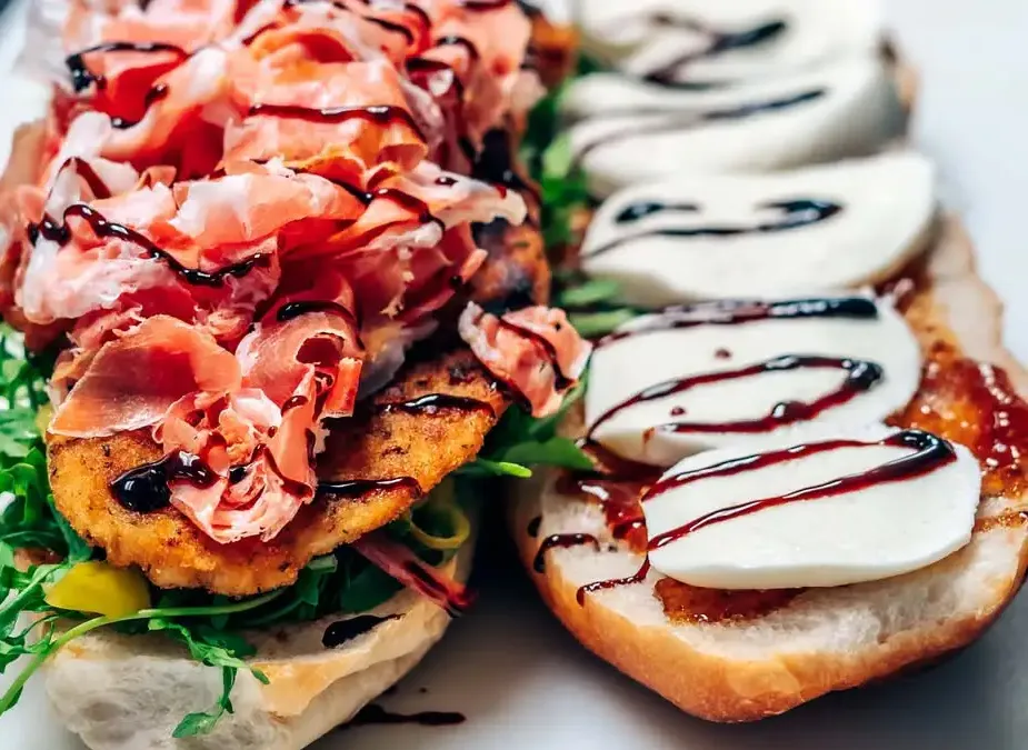 Ragz to Riches, split open: a breaded chicken cutlet under shaved prosciutto and arugula, fresh mozzarella with a balsamic glaze drizzle
